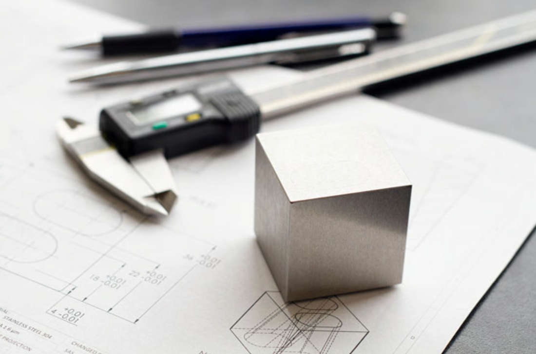 A MetMo Cube standing on technical drawings.